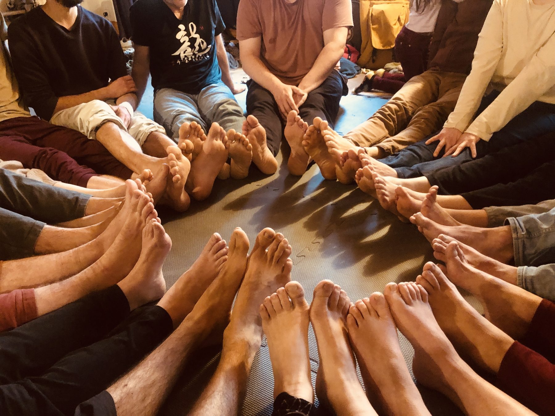 Les pieds des membres du collectif réunis en cercle